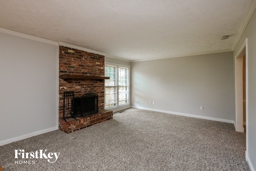 the living room of an empty house with a brick fireplace