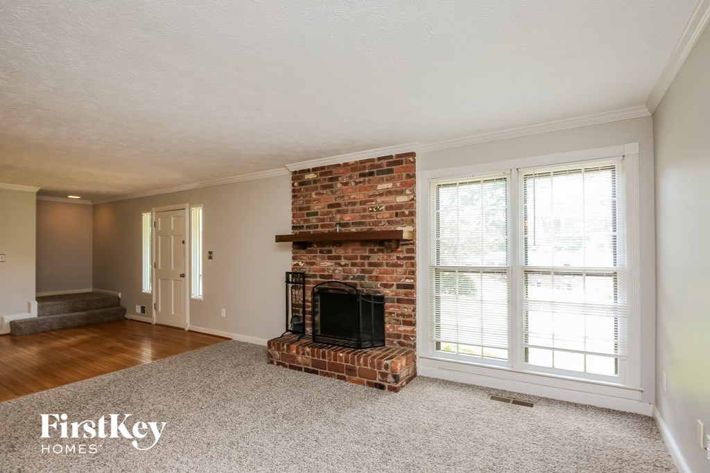 a living room with a brick fireplace and a window