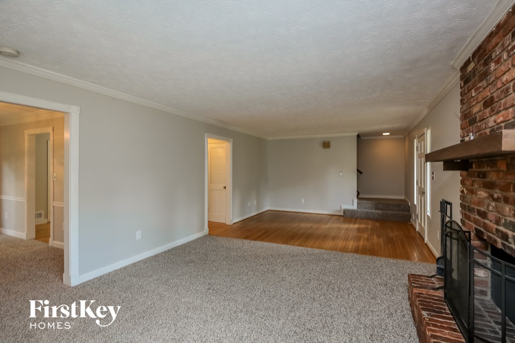 the living room of an empty house with a brick fireplace