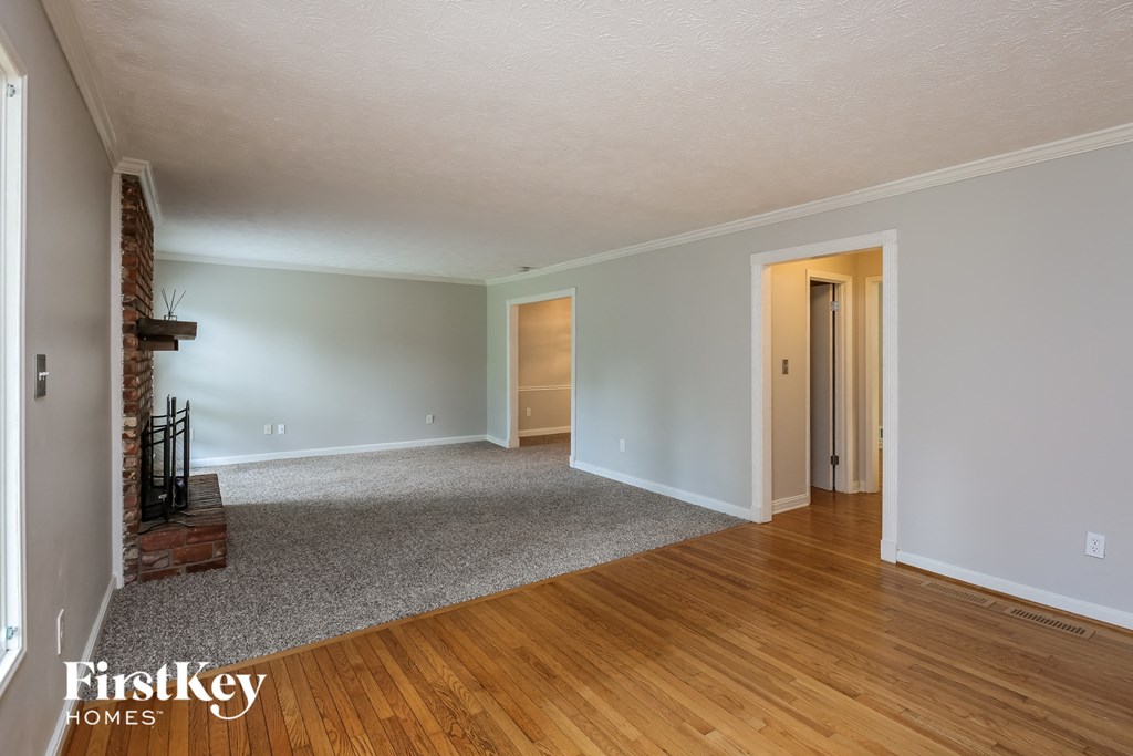 the living room of an empty house with wood floors and a fireplace