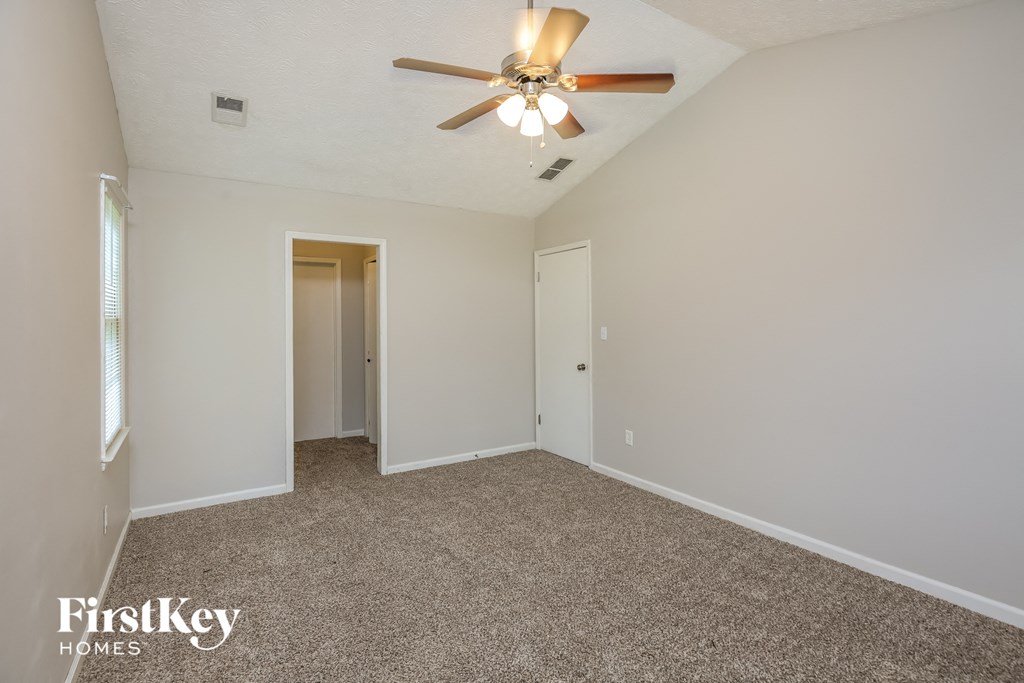 a bedroom with a ceiling fan and a carpeted floor