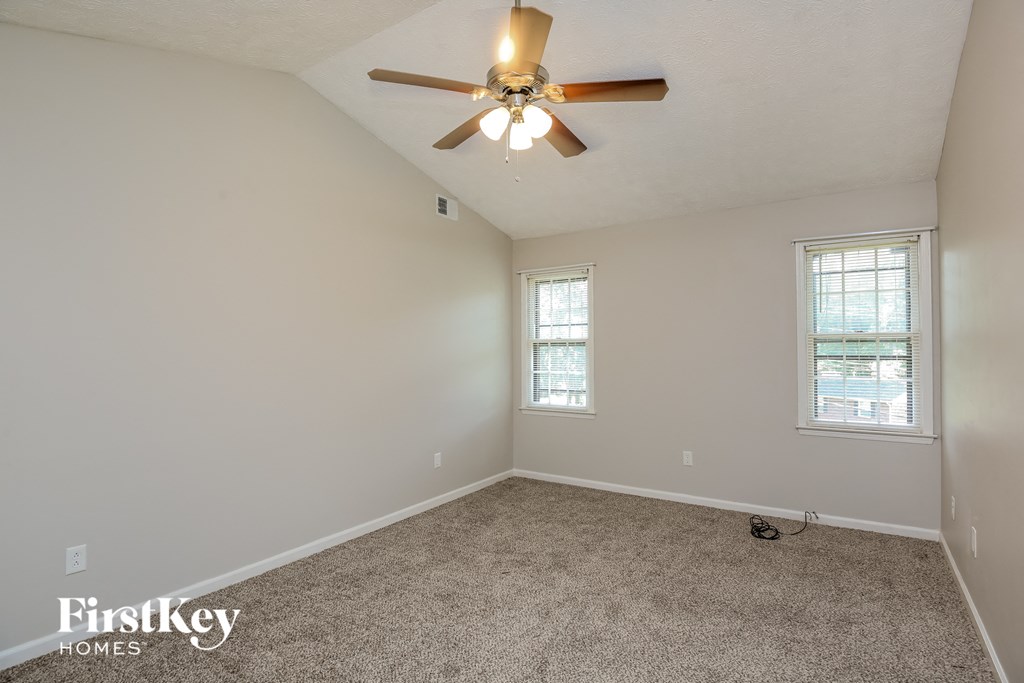 the living room of an empty house with a ceiling fan