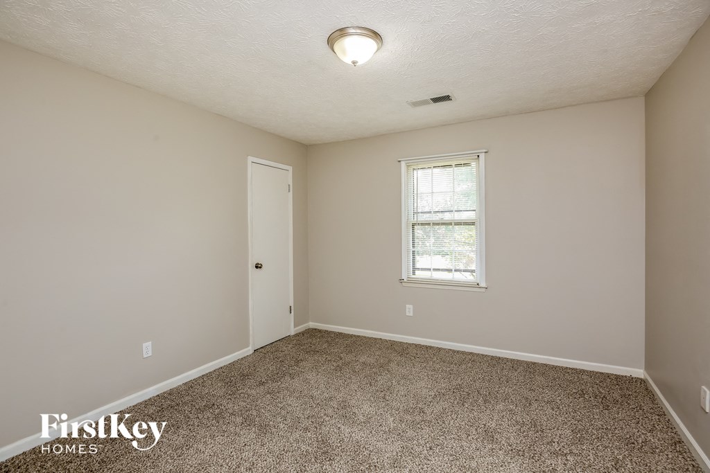 a bedroom with a carpeted floor and a window