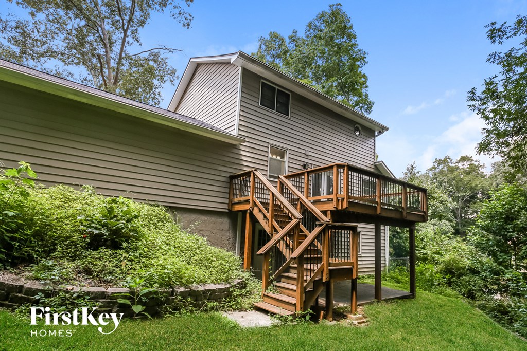 a house with a wooden deck on top of a yard