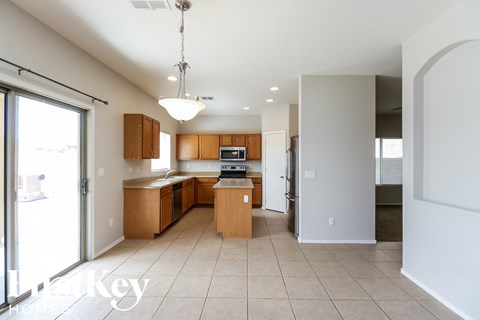 a large kitchen with wood cabinets and tiled flooring