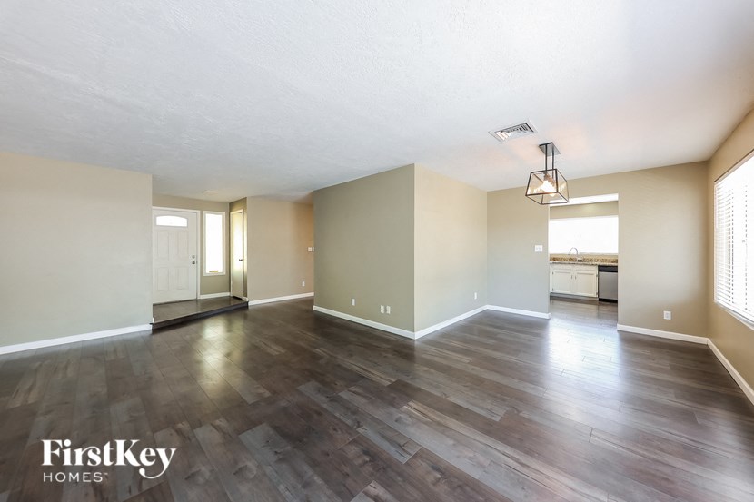 the living room and dining room of an apartment with hardwood flooring