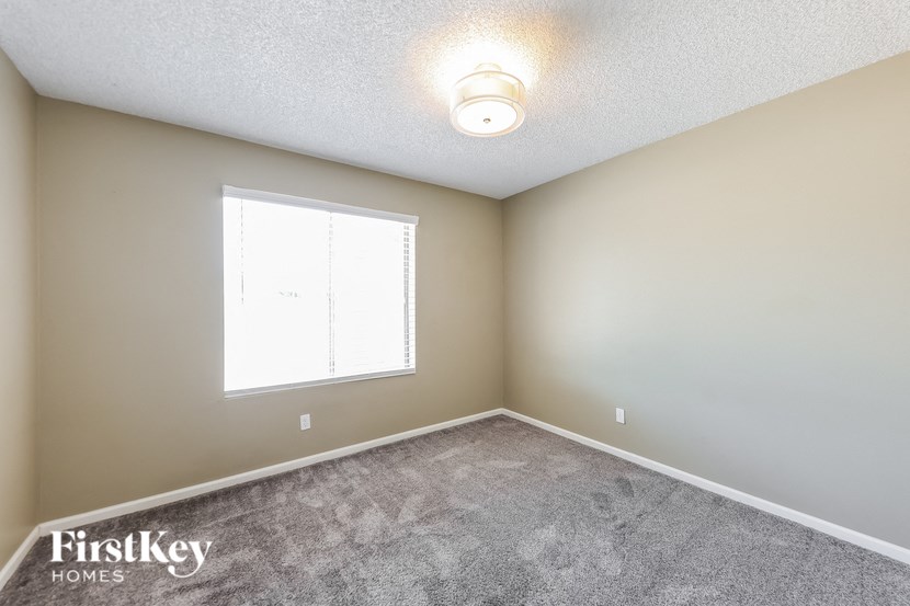 the upstairs bedroom has a carpeted floor and a large window
