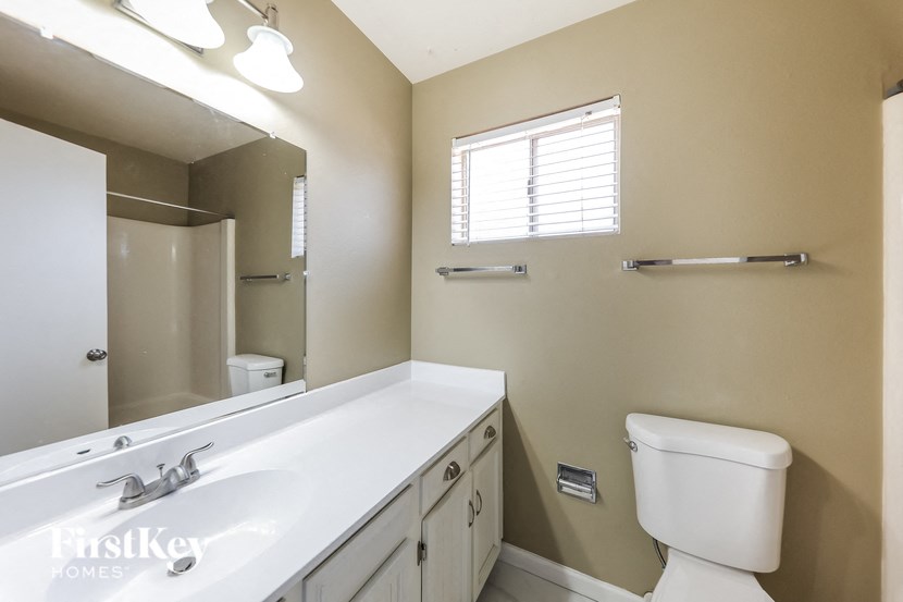 a bathroom with a sink toilet and a mirror