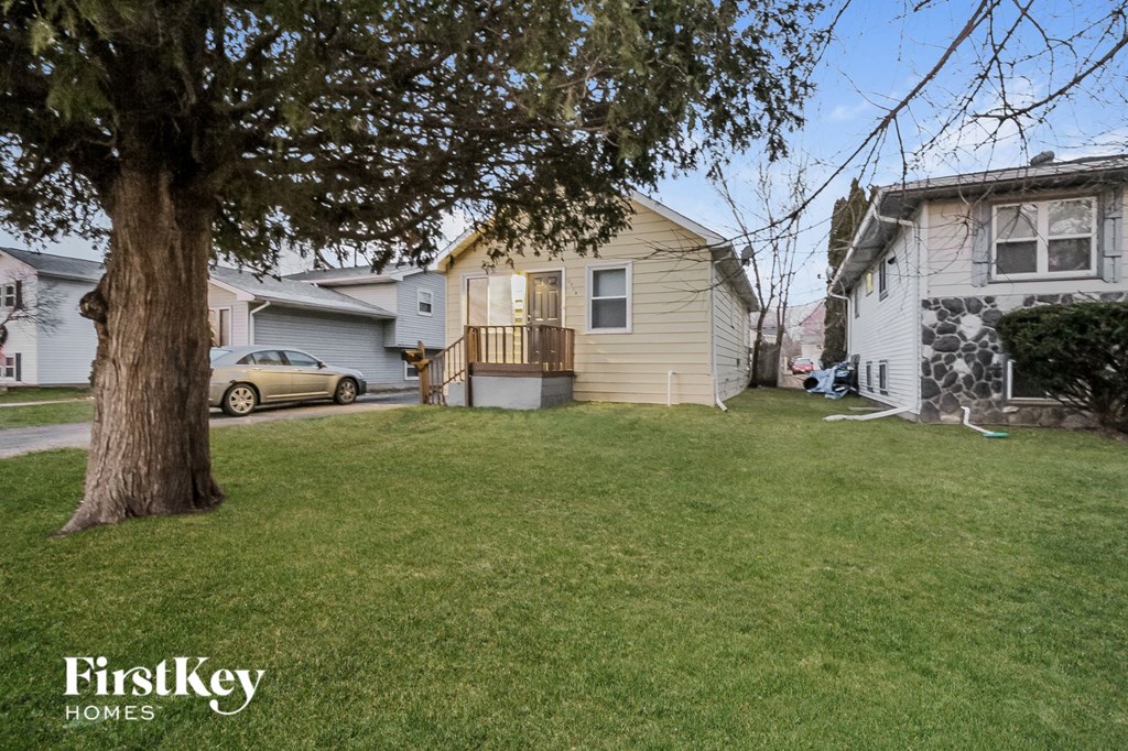 a house with a yard and a tree in front of it
