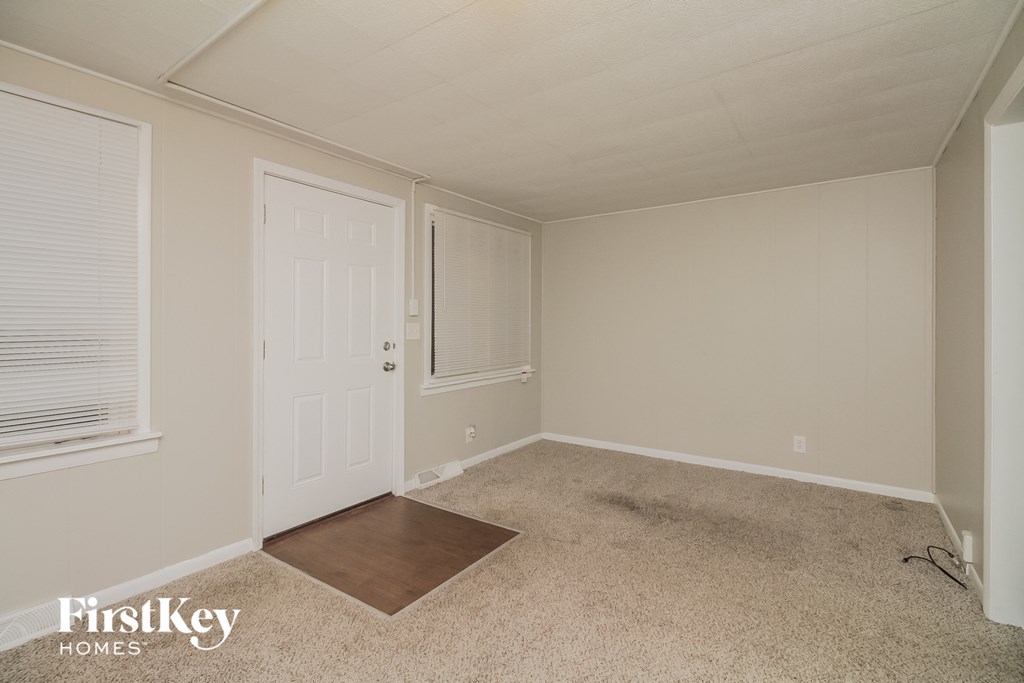 a bedroom with a white door and a carpeted floor