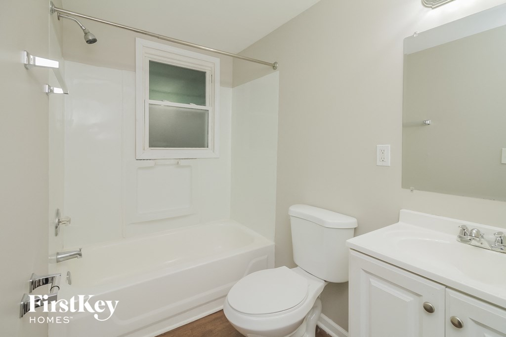 a bathroom with a toilet and a tub and a sink