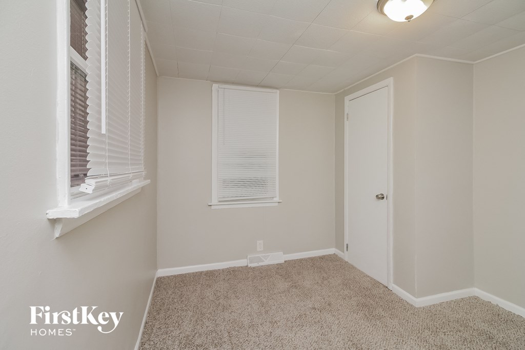 a bedroom with a carpeted floor and a white door