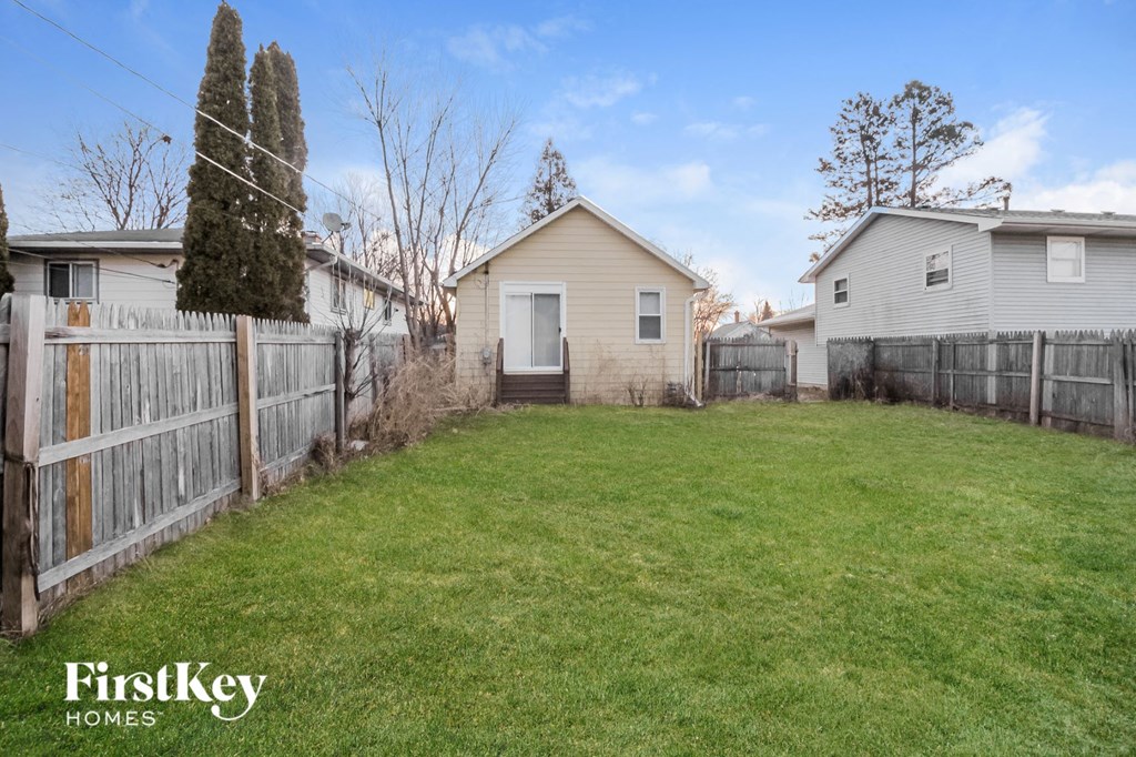the backyard of a house with a yard and a fence