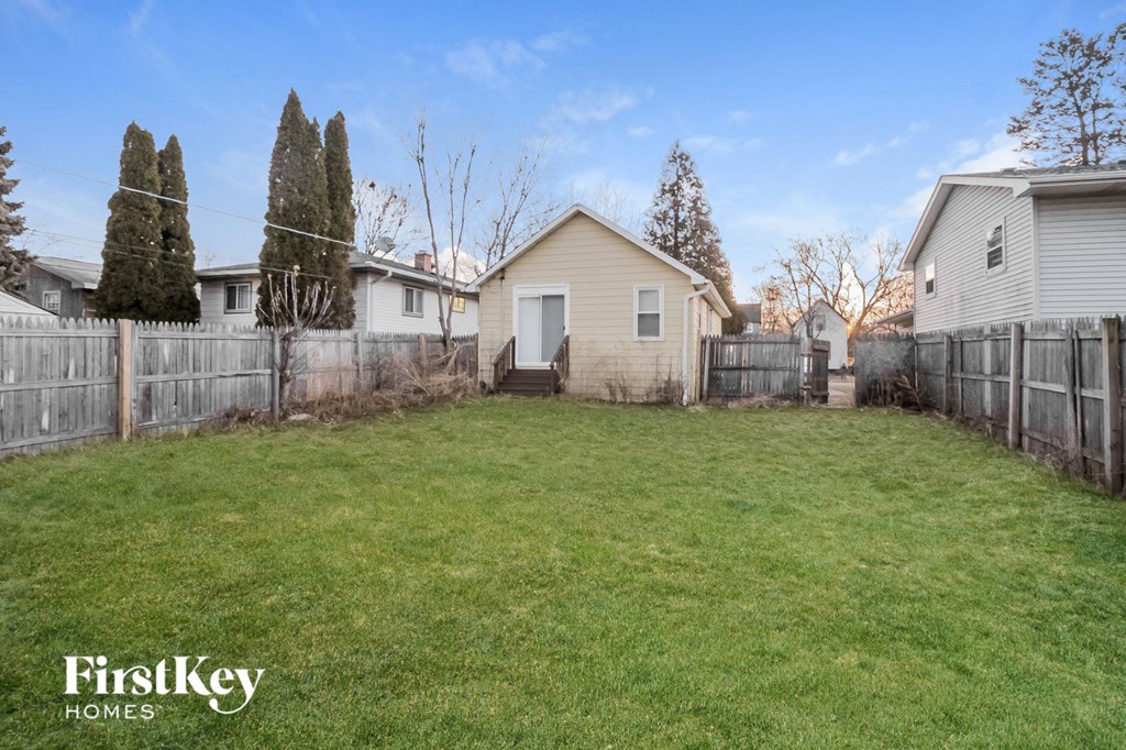 the backyard of a house with a yard and a fence