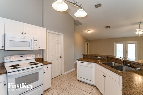 a kitchen with white appliances and granite counter tops