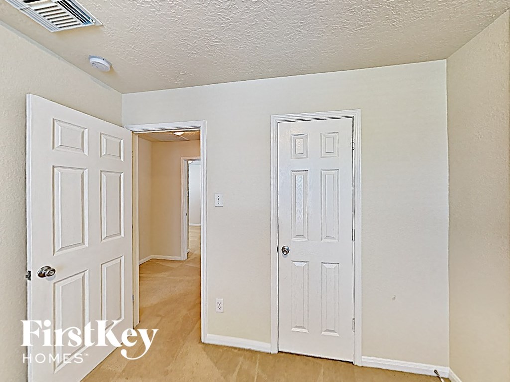 a bedroom with two closets and a door to a hallway
