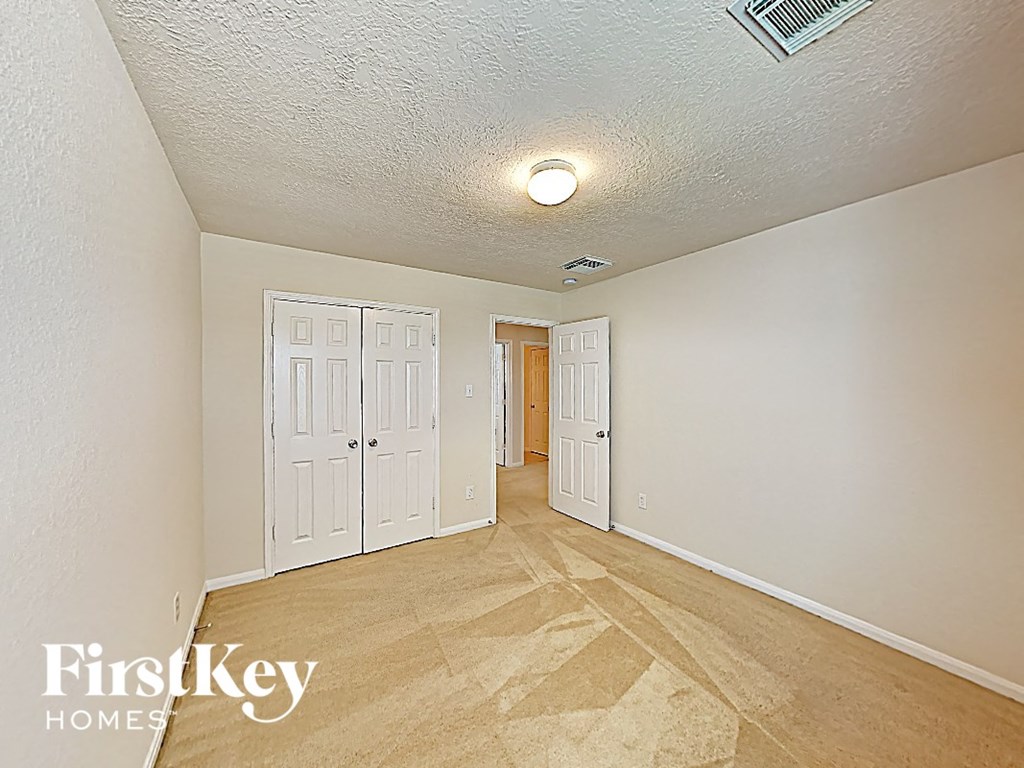 the living room and hallway of an empty house with wood flooring