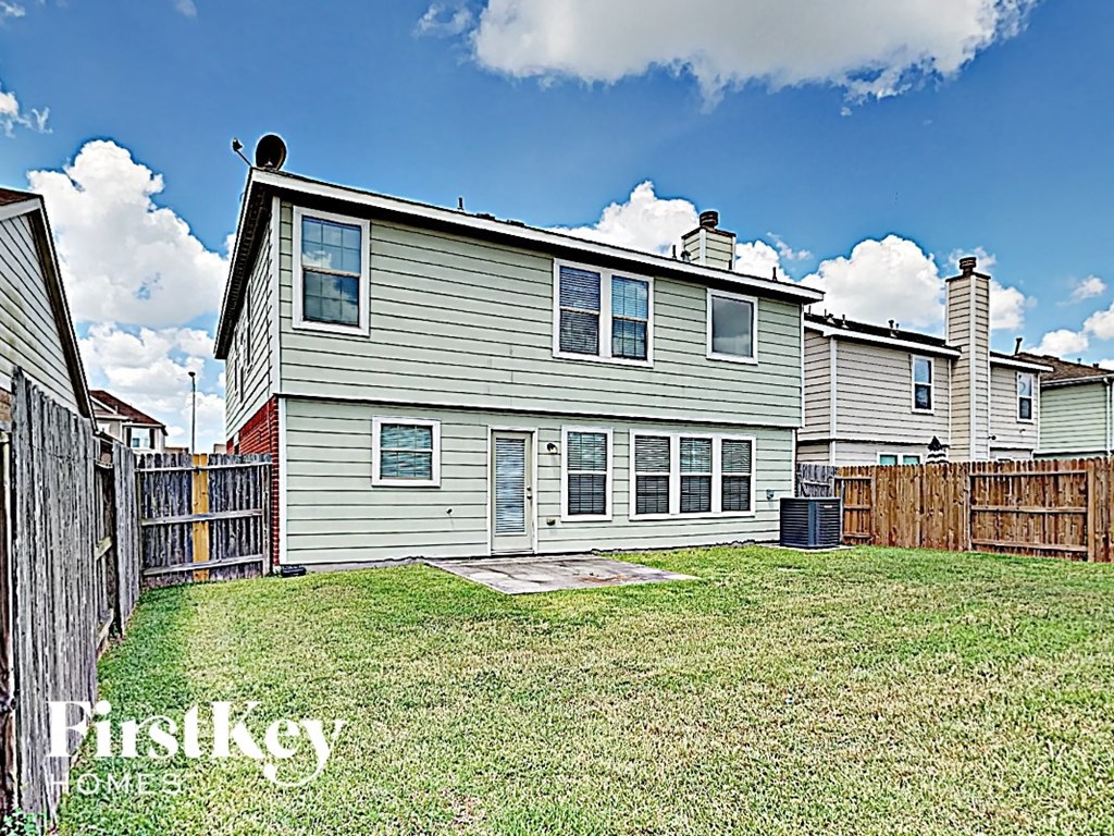 the back of a house with a yard and a fence