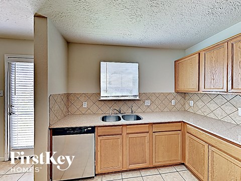 a kitchen with wooden cabinets and a sink and a dishwasher