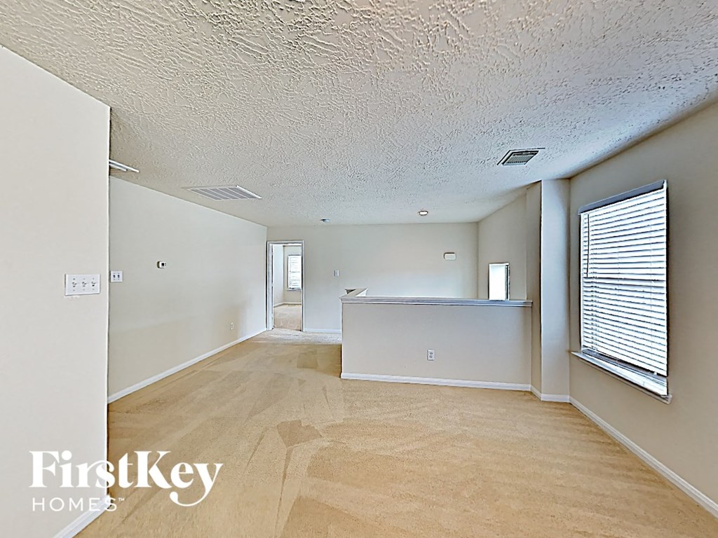 an empty living room and kitchen with a large window