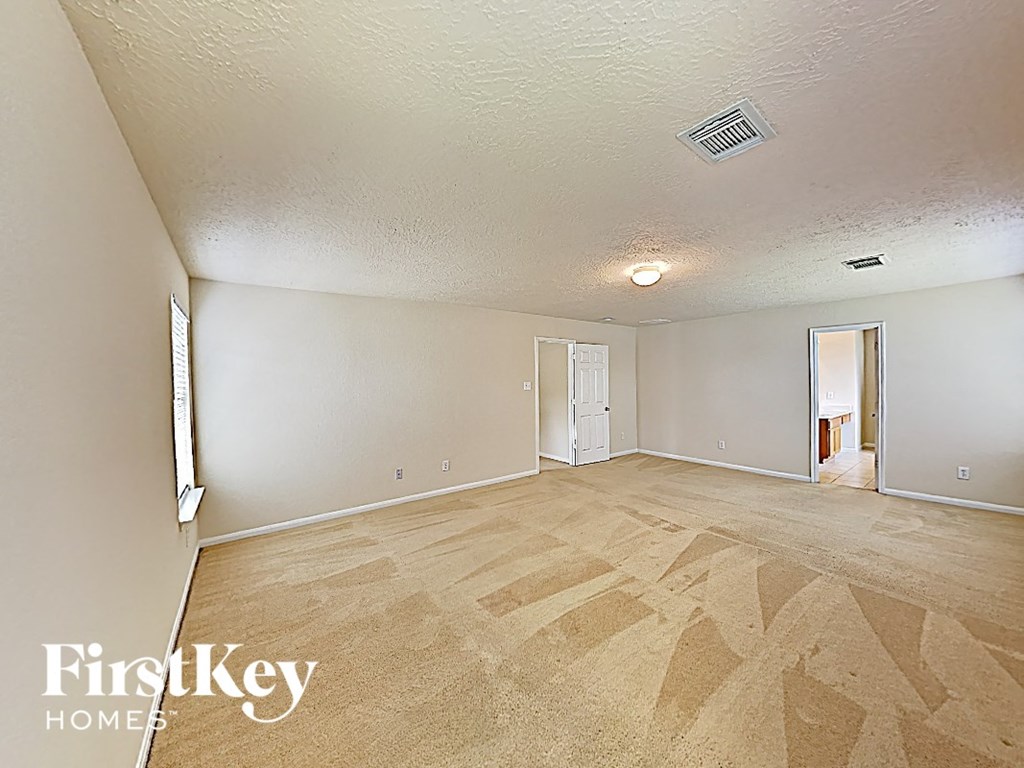 an empty living room with wood flooring and white walls