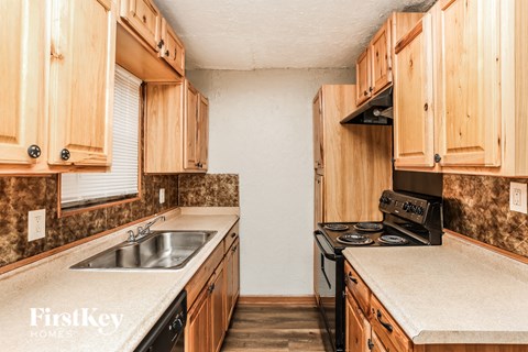 A kitchen with wooden cabinets and a stove top oven.