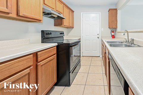 A kitchen with wooden cabinets and a black stove top oven.
