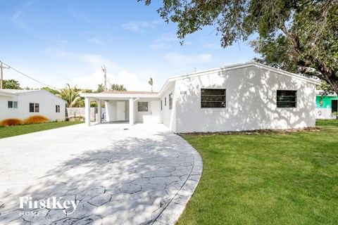 a white house with a driveway and a lawn