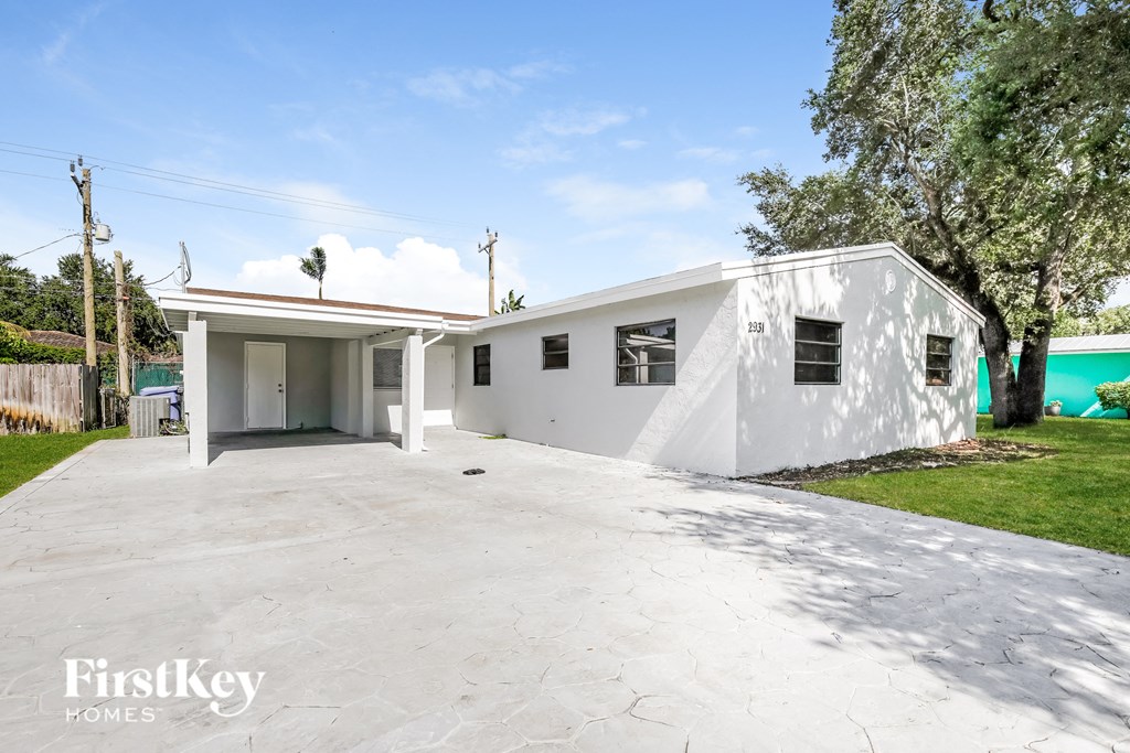 a white home with a driveway and a white house