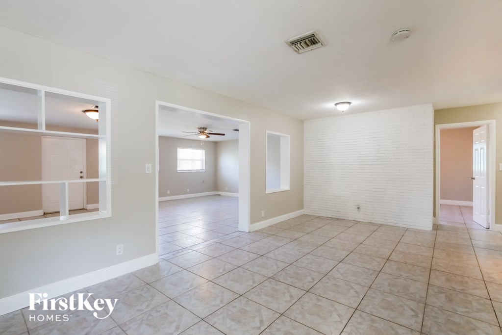 the living room and dining room are spacious with tile flooring and white walls