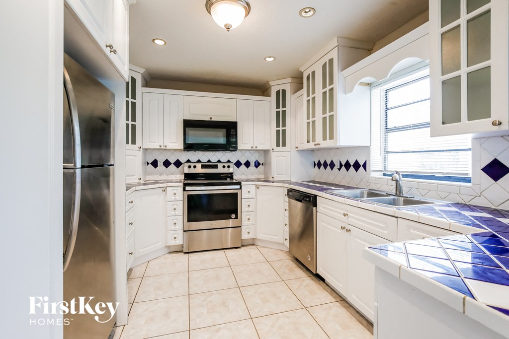 a kitchen with white cabinets and stainless steel appliances