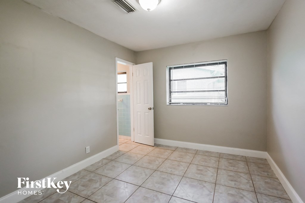 the living room of an empty house with a door and a window