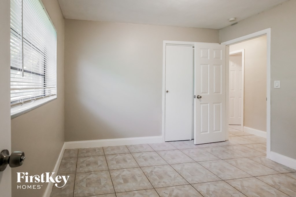 an empty room with a white door and a window