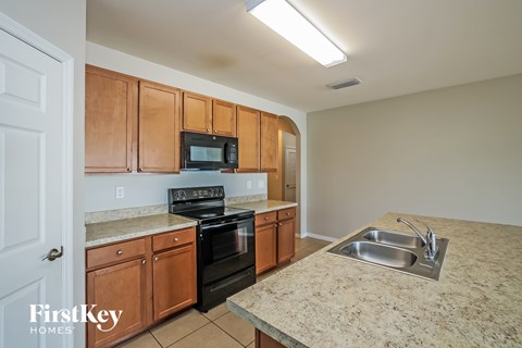 A kitchen with wooden cabinets and a granite countertop.