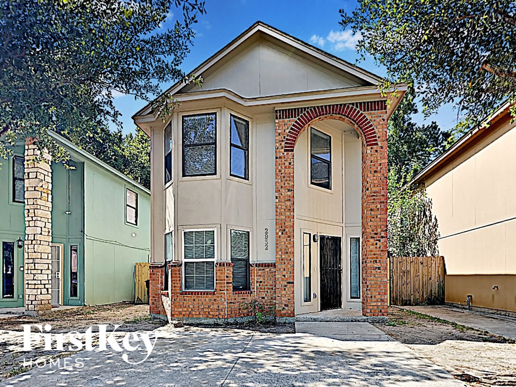 a small brick house with a large archway in front of it