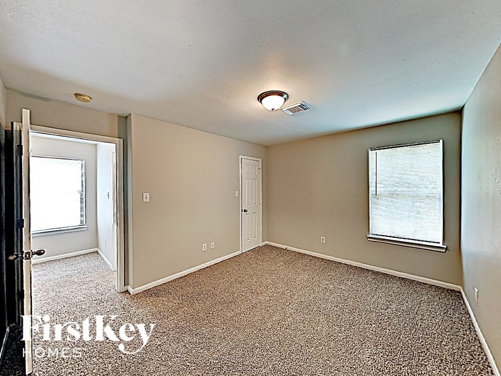 an empty bedroom with a door and a window