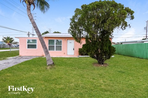 A pink house with a palm tree in front.