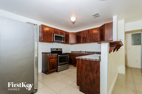 A kitchen with wooden cabinets and a refrigerator.