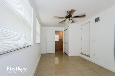 A spacious hallway with a ceiling fan and two doors.