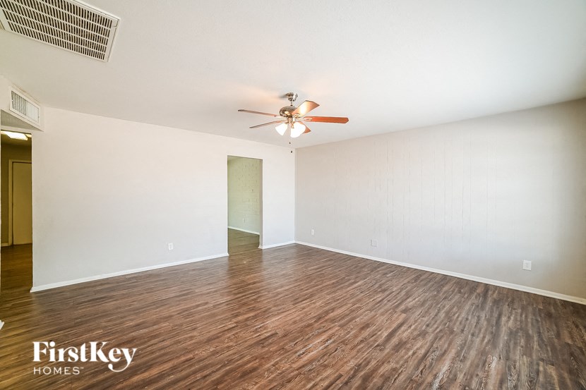 A room with wooden flooring and a ceiling fan.