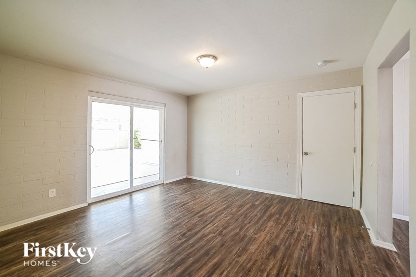 A room with wooden floors and a sliding glass door.