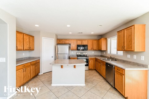 a kitchen with wooden cabinets and a white island in the middle