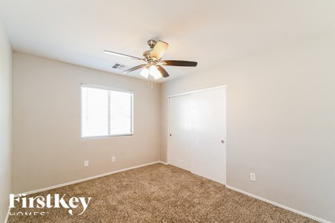 a bedroom with carpet and a ceiling fan