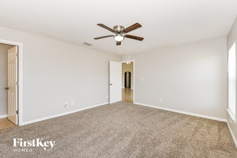 a living room with carpet and a ceiling fan