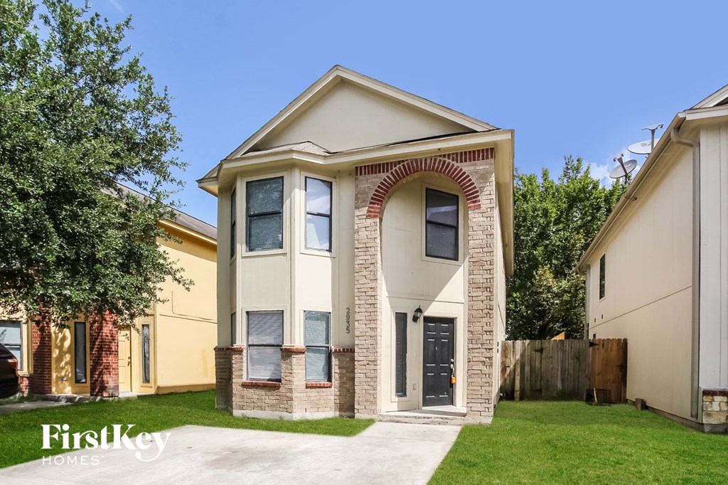 the front of a house with a driveway and grass