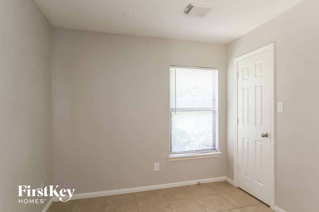 a bedroom with a window and a white door