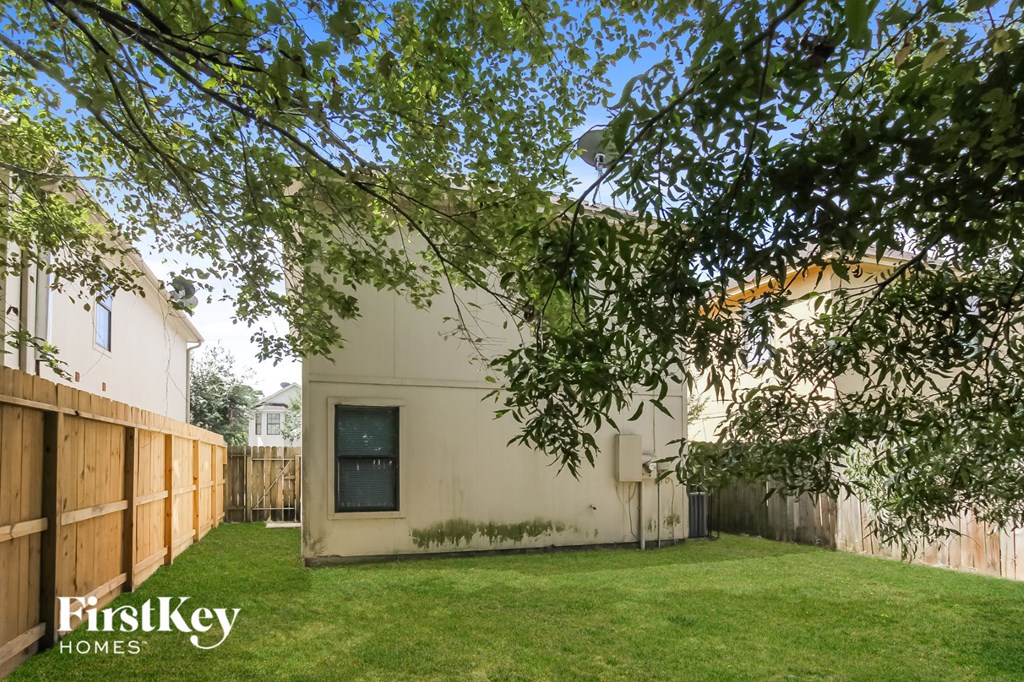 the backyard of a house with a yard and a wooden fence