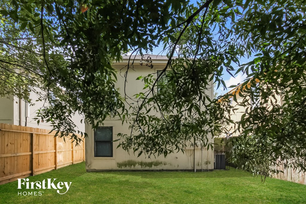 a small house with a yard and a tree