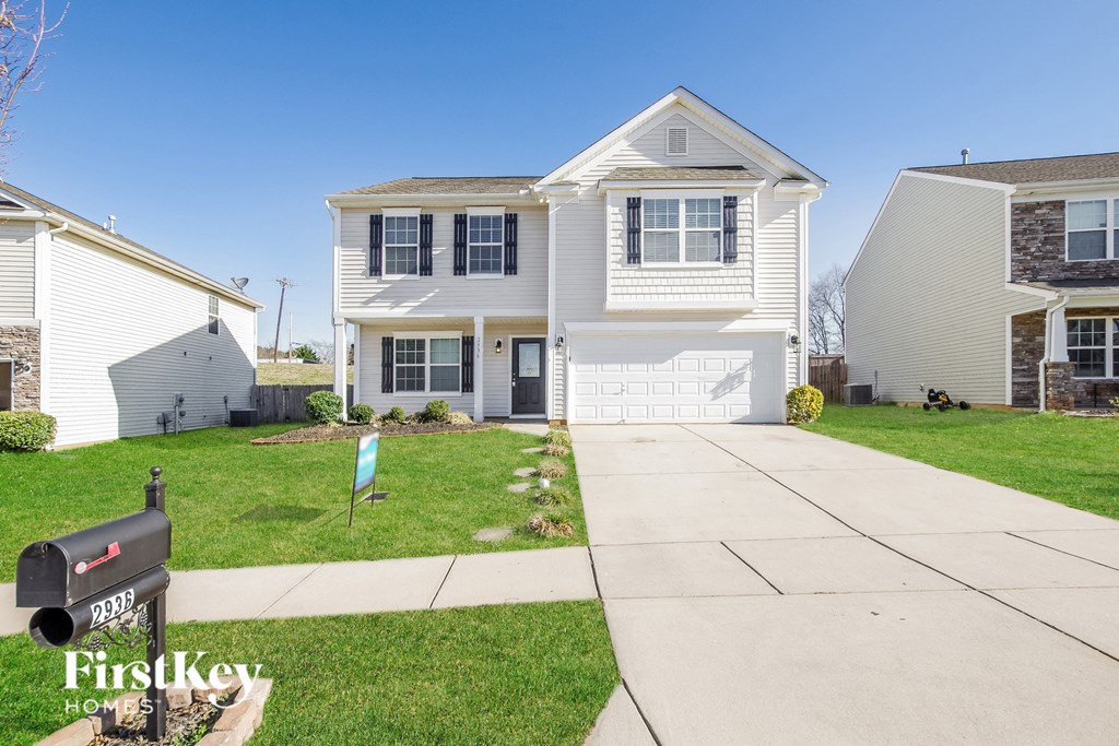 a white house with a sidewalk in front of it