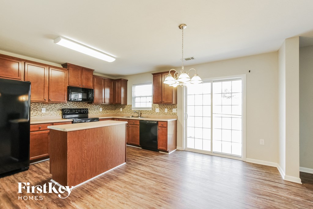 an empty kitchen with wooden cabinets and a large window
